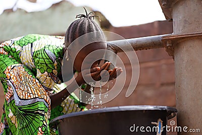 Nicely Braided African Girl Washing Her Face With Fresh Water At the Borehole Stock Photo