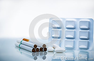 Nicotine chewing gum in blister pack near pile of cigarette. Quit smoking by use nicotine gum for relief of nicotine withdrawal Stock Photo