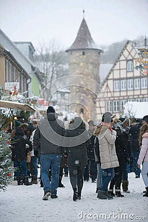 Schimmelturm Rising above Traditional Christmas Market. People on the Street, Christmas Trees and Kiosks, Falling snow. Editorial Stock Photo