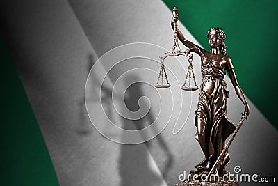 Nigeria flag with statue of lady justice and judicial scales in dark room. Concept of judgement and punishment Stock Photo