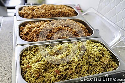 Nigerian Jollof and Vegetable Fried Rice served in Chaffing dish Stock Photo