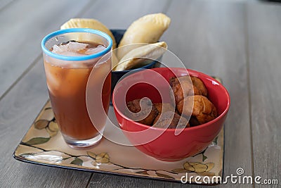 Nigerian Puff Puff and meatpie snacks served with iced tea Stock Photo