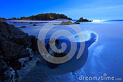 Night at the beach: tide pools and rocks illuminated by the moon Stock Photo