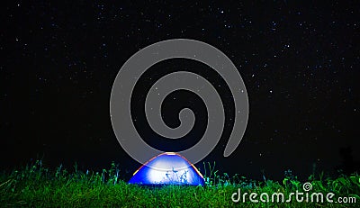 Night camping. campfire near illuminated tent under amazing nigh Stock Photo