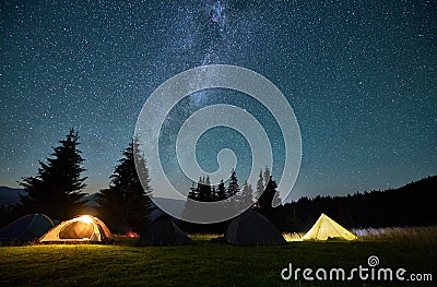 Night camping in mountains under starry sky. Stock Photo