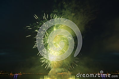 night city sky bright explosion green fireworks above river Stock Photo