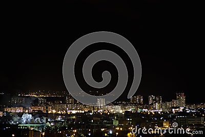 Night city skyline timelapse. Top aerial panoramic view of modern city from tower rooftop. Road junction traffic. Stock Photo