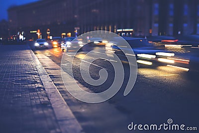 Night city street with cars on the road, close up view from asphalt level Stock Photo