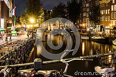 Night city view of Amsterdam bridge and typical dutch houses, Holland, Netherlands. Editorial Stock Photo