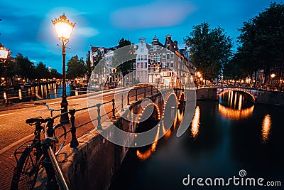 Night cityview of Famous Keizersgracht Emperor`s canal in Amsterdam, tranquil scene with street lantern, illuminated bridge at Stock Photo