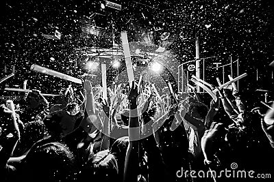 Night club silhouette crowd hands up at confetti steam stage Editorial Stock Photo