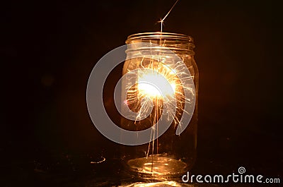 Night fireworks sparkler burning inside glass jar Stock Photo