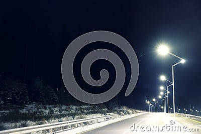 Night landscape with illuminated road and forest Stock Photo