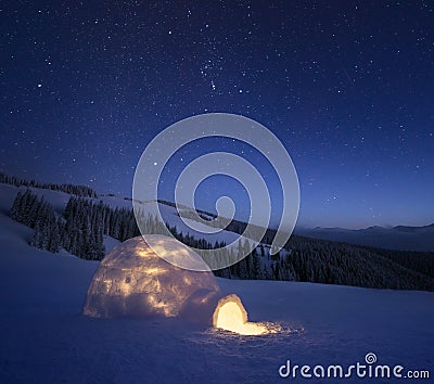 Winter night landscape with a snow igloo and a starry sky Stock Photo