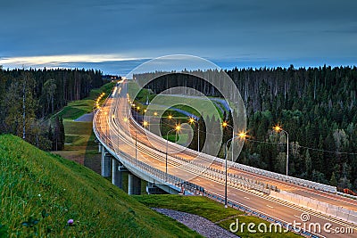 Night lighting a road overpass in the woods. Stock Photo