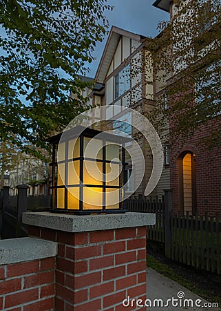 Night lights in the park. Latern glow in night garden. Dark street at night with light of latern shining on the wall Stock Photo