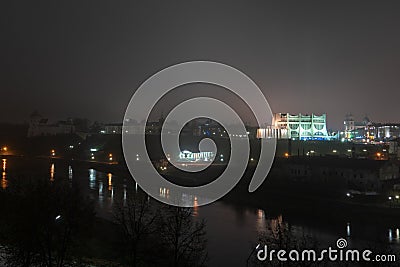 Night panorama of the big city at the foot of the river. Lots of colorful burning lights and street lighting. Top view of houses Stock Photo