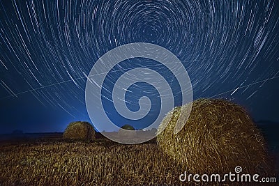 Night photo with star circles on the field with haystacks. Stock Photo