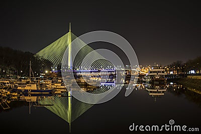 Night picture of the bridge on the ada with reflection in the clear water while the lighting is overflowing Stock Photo