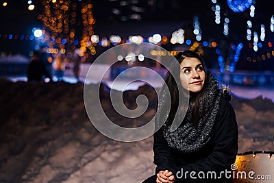 Night portrait of a beautiful brunette woman smiling enjoying winter in park.Winter joy.Winter holidays.Positive emotions. Stock Photo