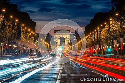 Night scence illuminations traffic street of the Impressive Arc de Triomphe Paris along the famous tree lined Avenue des Champs- Stock Photo