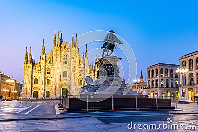 Night scene of Duomo cathedral in Milano viewed behind statue of king Vittorio Emanuele II Editorial Stock Photo