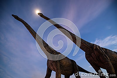 Night scene shot two big dinosaur stucco and the moonlight with clouds sky Stock Photo