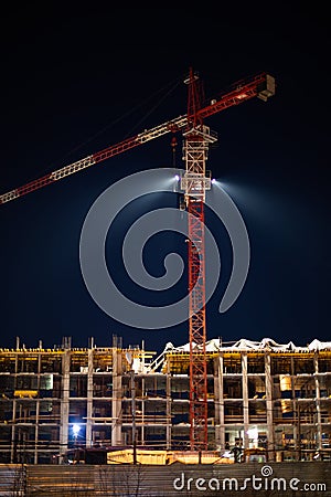 Night shooting, construction of an apartment building, erection of the floors of a multi-storey building. Construction crane Editorial Stock Photo
