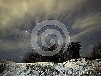 Night sky Lyra constellation stars clouds and snow observing winter landscape Stock Photo