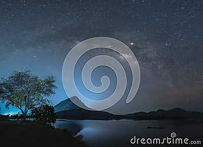 Night sky with stars and The Milky Way is above the mountain and reflection on the water Stock Photo