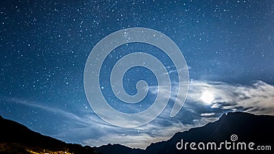 Night sky stars and moon across mountain Stock Photo