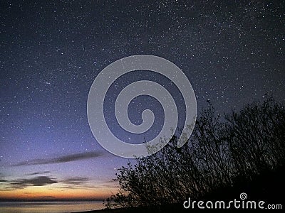 Night sky stars observing Perseus constellation over sea Stock Photo