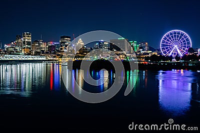 Night skyline at Dieppe Park with an illuminated Ferris wheel and light reflections on the river Stock Photo