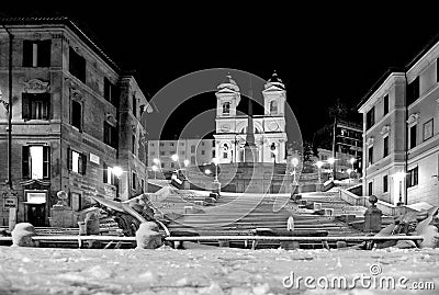 Night snowfall on empty Spanish square and steps in Rome with church Trinita di Monti in background, Italy. Piazza di Spagna Stock Photo