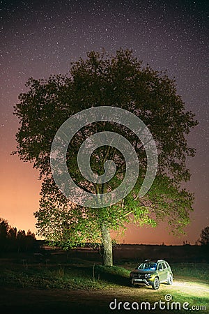 Night Starry Sky Above Car Renault Duster. SUV parked near lonely tree in night forest. Editorial Stock Photo