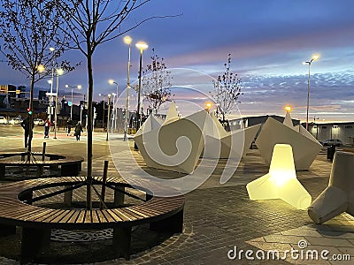 Night street art , neon blurred light, blue sky and moon, modern installation as white ship decoration, people walk and relax in Editorial Stock Photo