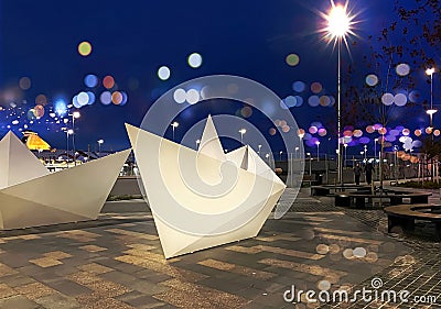 Night street art neon blurred light and modern installation white ship decoration people walk and relax in Tallinn Estonia Editorial Stock Photo