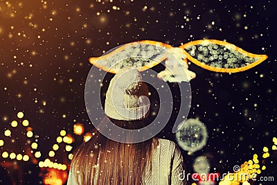 Night street portrait of beautiful young woman walking at festive Christmas fair. Back view. Lady wearing classic winter Stock Photo