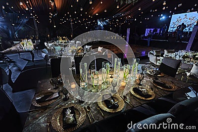 Night table set for dining and flowers decoration with candles at night, indoor luxury wedding with low light romantic ambient Stock Photo