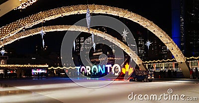 Night view across the brightly illuminated for New Year eve skating rink with TORONTO sign on the central Nathan Editorial Stock Photo