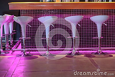 Night view of bar stand with cozy white decorative chairs Stock Photo