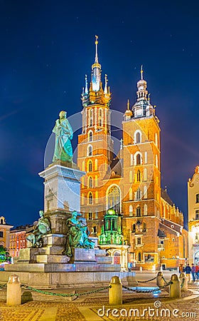 Night view of the church of Saint Mary with statue of adam mickiewicz on the rynek glowny main square in the polish city Stock Photo