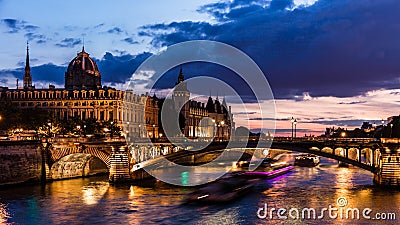 Night view of Conciergerie Castle and Pont Notre-Dame bridge over river Seine. Paris, France Stock Photo