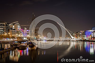 Night view of Dublin with water, bridge and buildings. Editorial Stock Photo