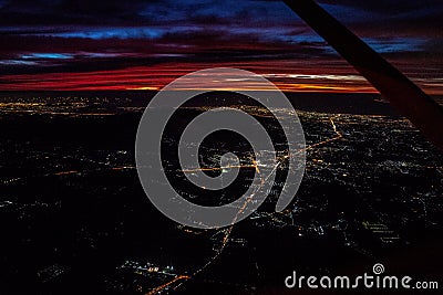 Night view from the jetplane in twilight time with the red sky and light of the city Stock Photo