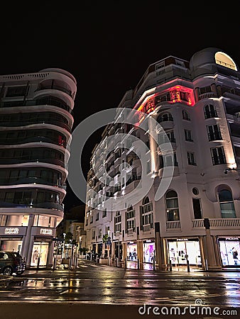 Night view of modern buildings in the downtown of Cannes, French Riviera, France in evening with illuminated shop windows. Editorial Stock Photo