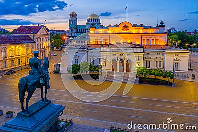 Night view of the National Assembly of the Republic of Bulgaria and Alexander Nevski cathedral in Sofia. Sign translates - Unity Editorial Stock Photo