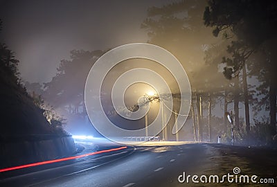 The night view of the pass road is full of fog with magical street lights Stock Photo