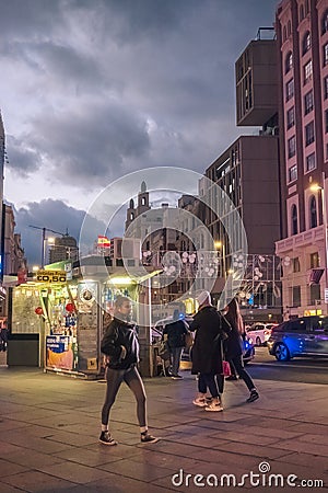 Night view of people passing near a street kiosk in Callao Madrid Spain Editorial Stock Photo