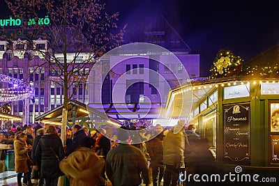 Night view of people on street around stalls of Christmas market Editorial Stock Photo